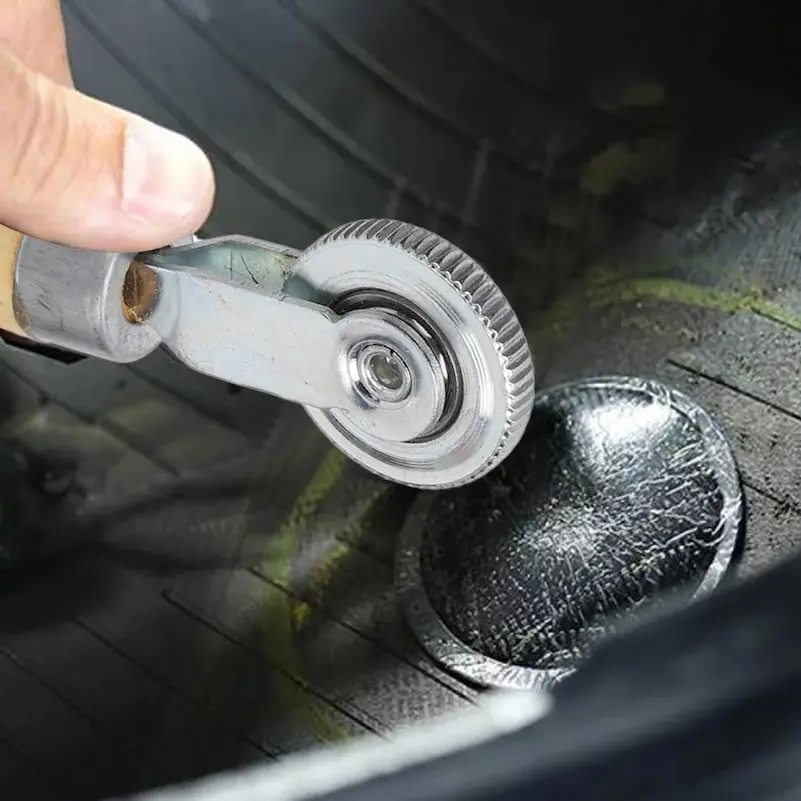 A plug being worked into the tread of a tyre with a repair tool