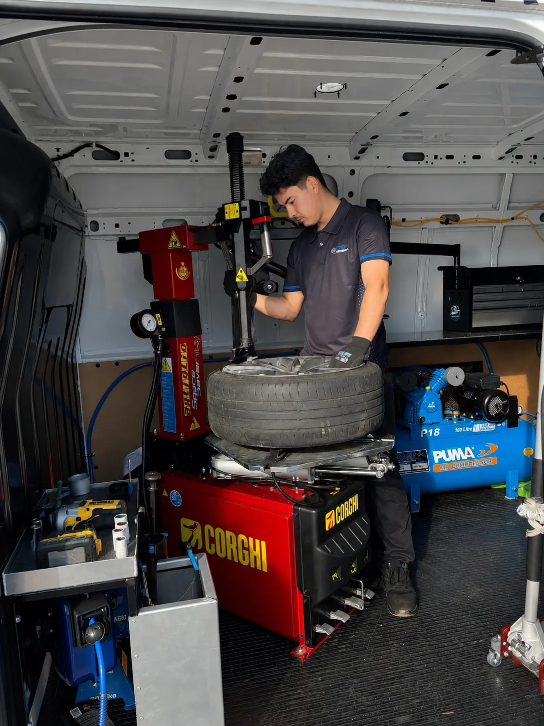 A fitter seating a new tyre onto an alloy wheel on a tyre machine